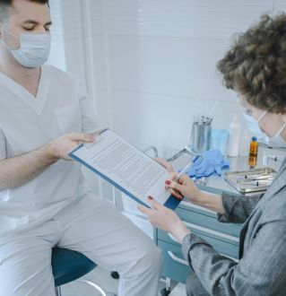 A medical professional and patient reviewing documents in a clinic setting.